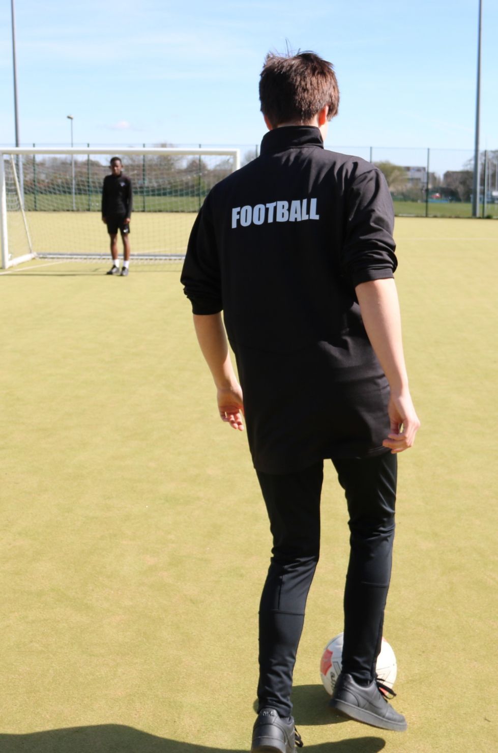 girl wearing a sports top saying football