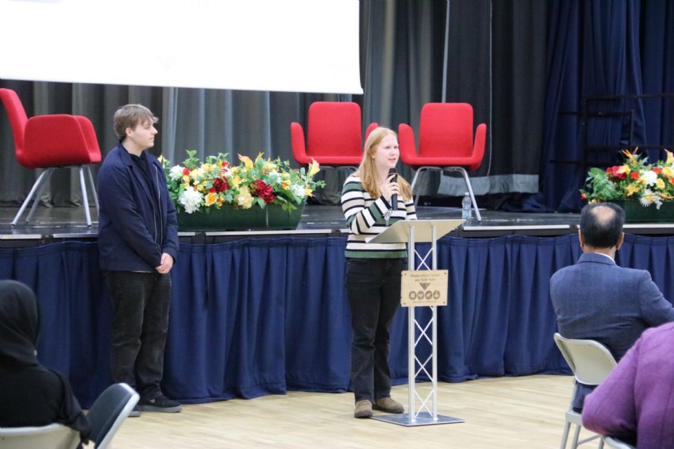 student talks to the audience in the school hall
