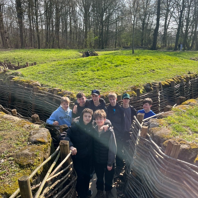 students stand in trenches on their visit to Belgium battlefields