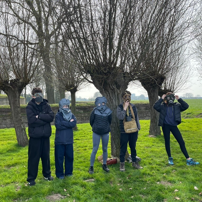 students try on gas masks on their visit to Belgium battlefields