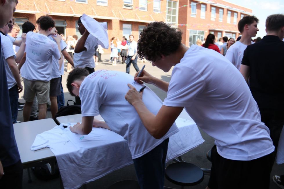 students signing t shirts