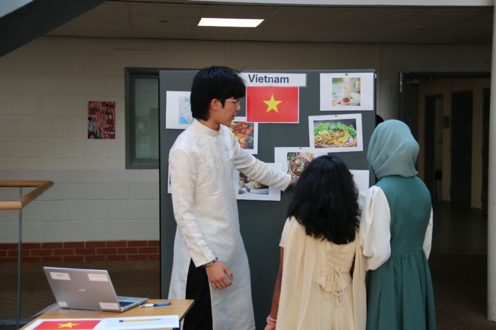 students dressed in cultural clothes at a stall showing their country