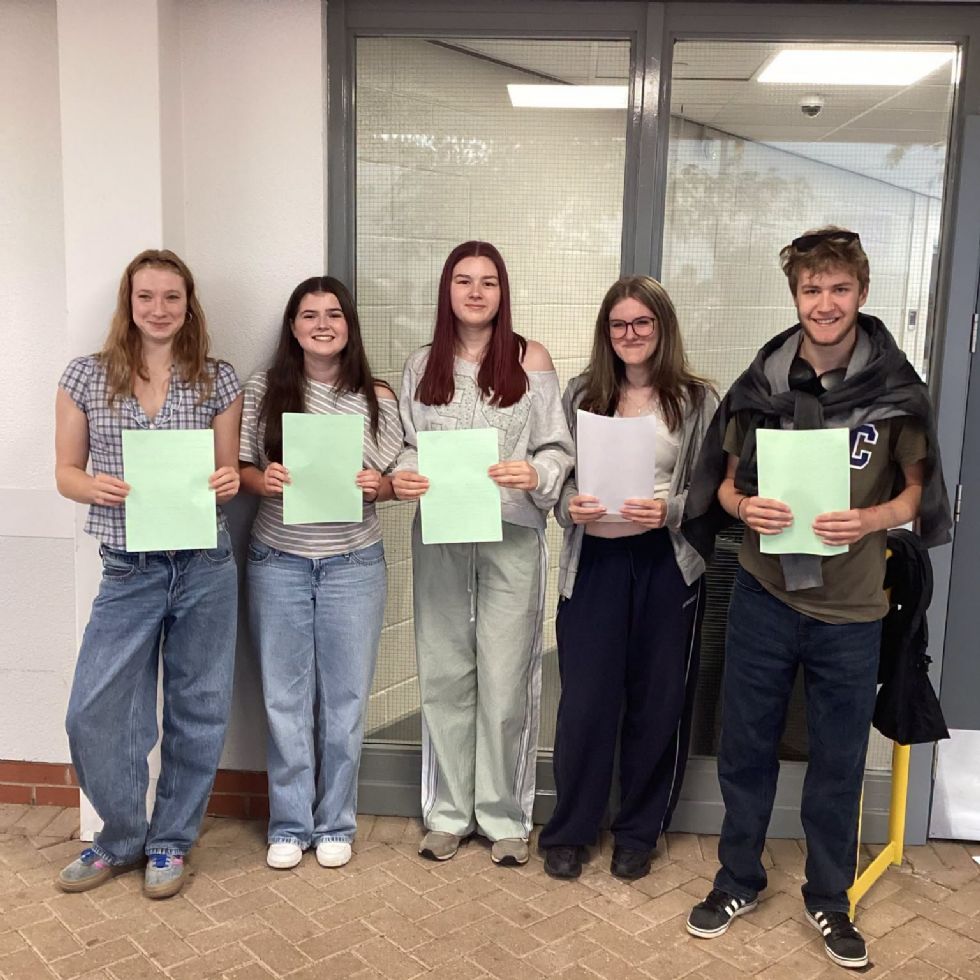 students smiling with their GCSE results