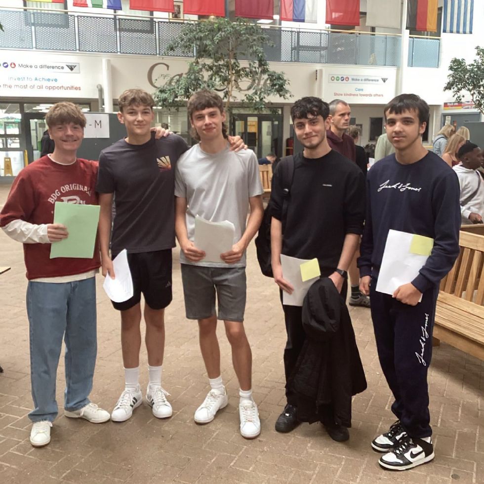 students smiling with their GCSE results