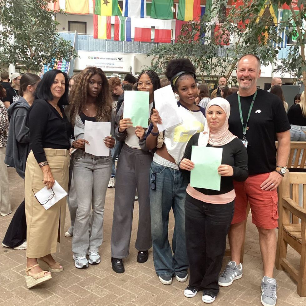 students smiling with their GCSE results