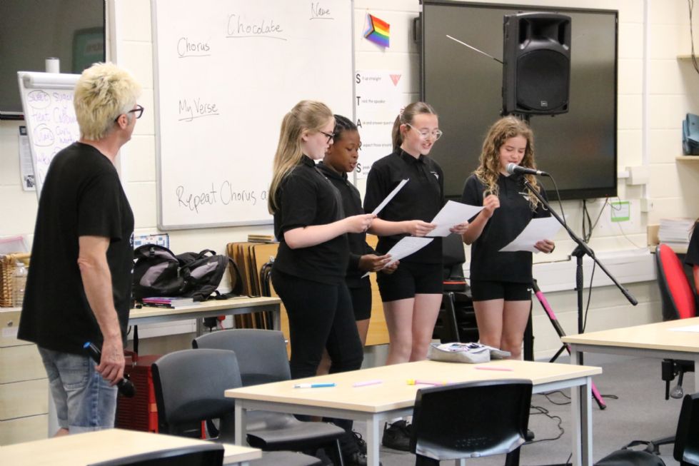 poet with students at the microphone in a poetry workshop