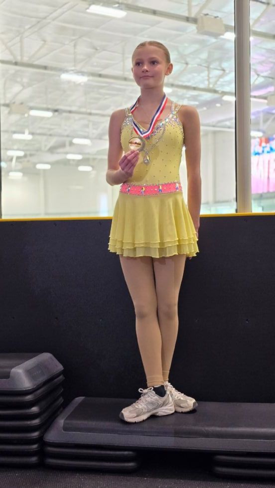 student with ice skating medal