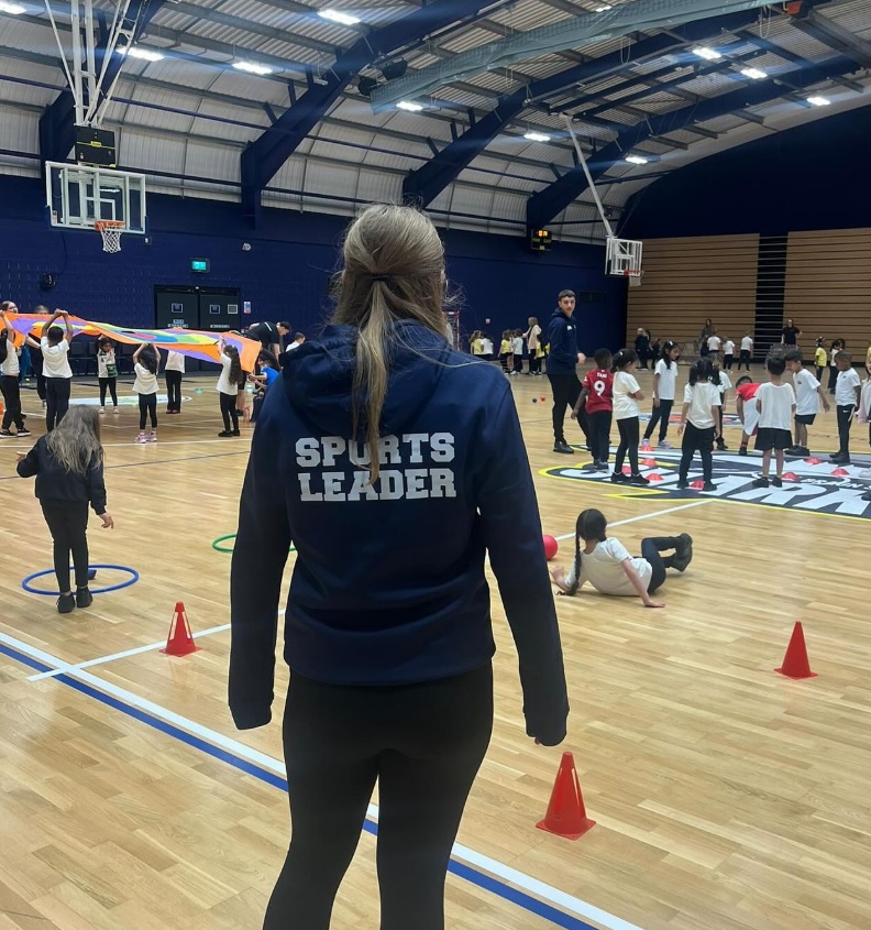 secondary aged student in sports leader top at an arena event