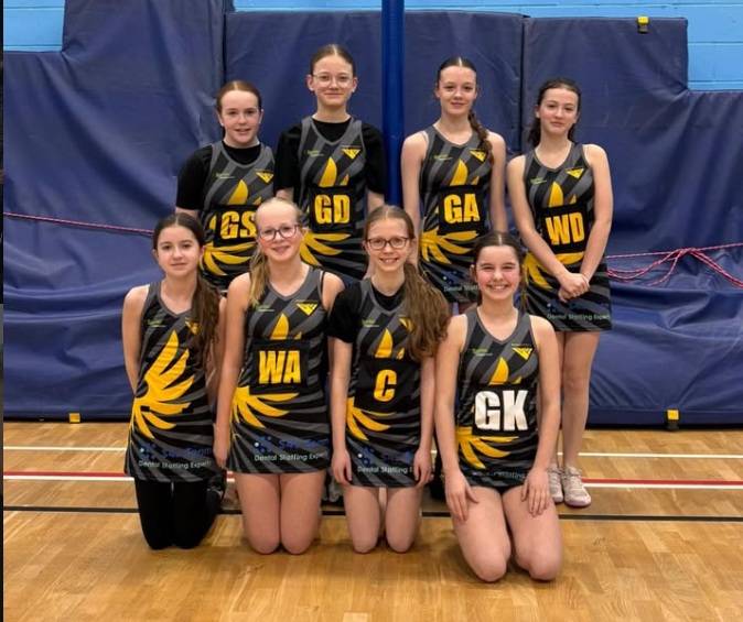 y8 netball team pose after their match win