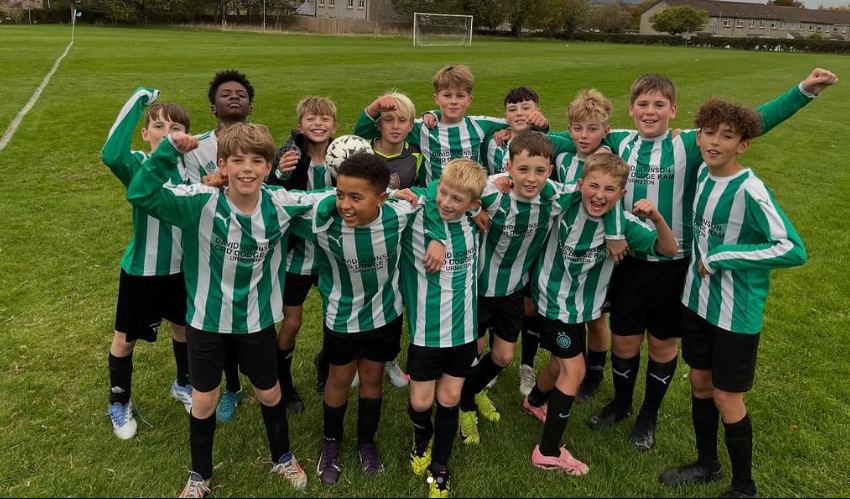 y7 football team raising their arms in victory