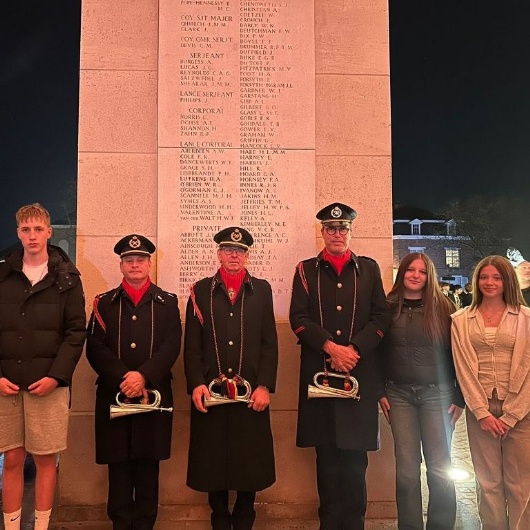 students stand with buglers at the Thiepval monument