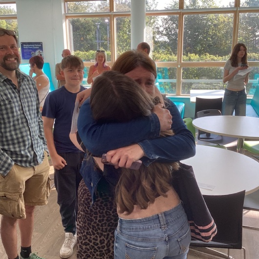 Students hugging after getting their a level results