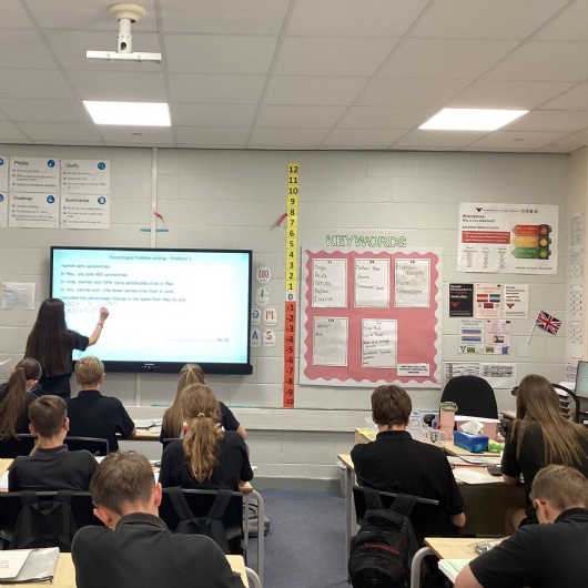 student in front of the white board in a maths lesson